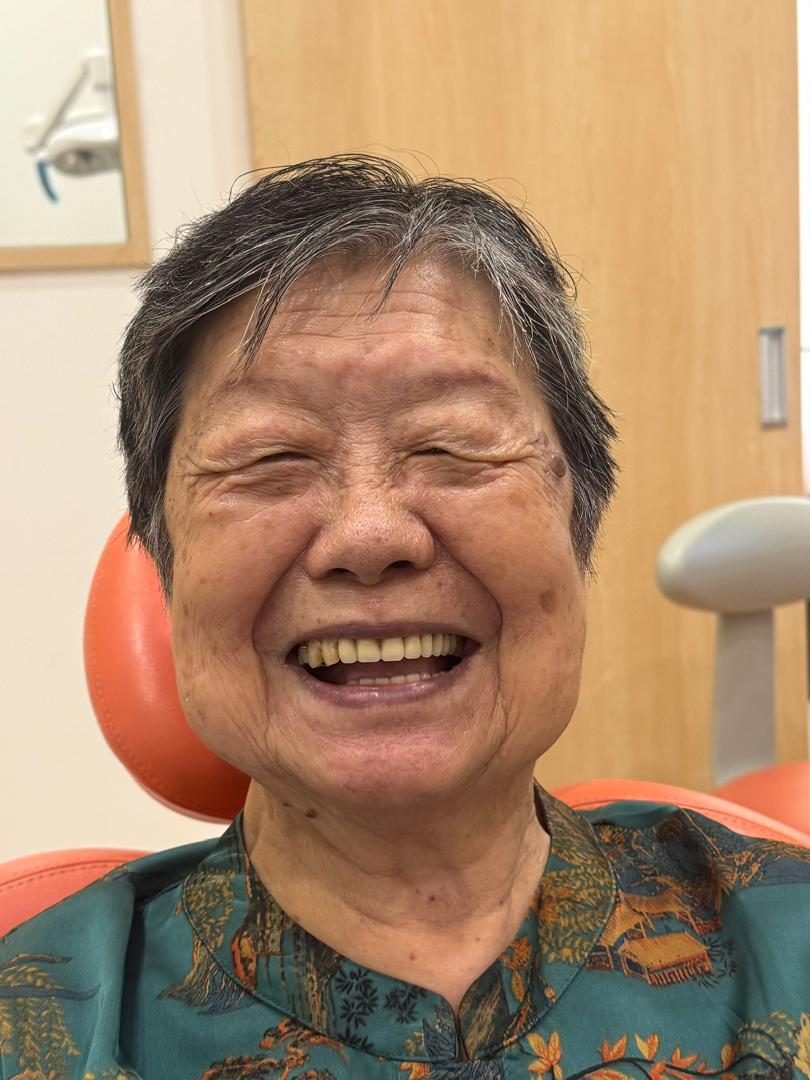 A denture patient smiling at A M Dental