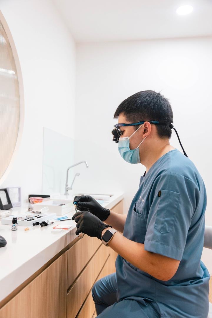 A dentist working with magnification loupes at A M Dental
