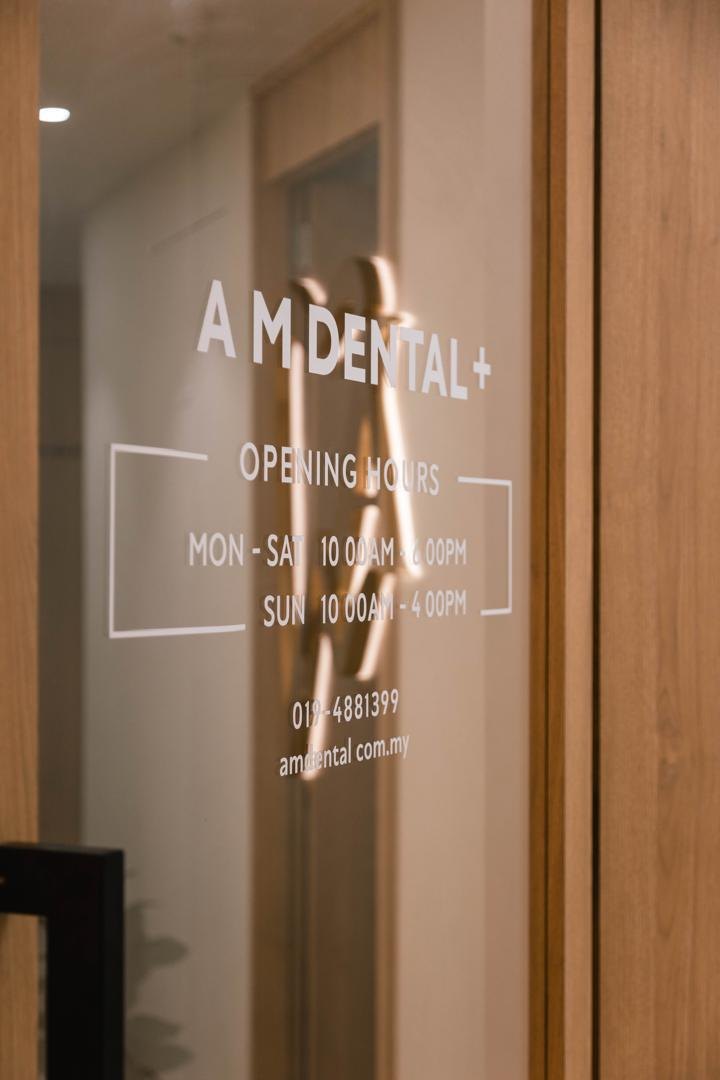 The A M Dental entrance door showing the opening hours